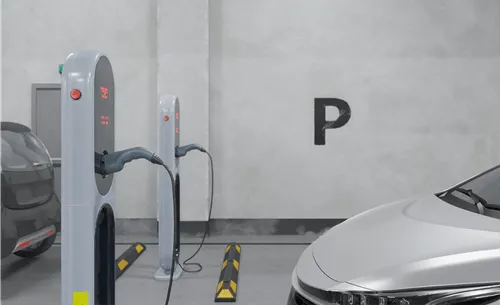 Car charging at EV hub in industrial setting.