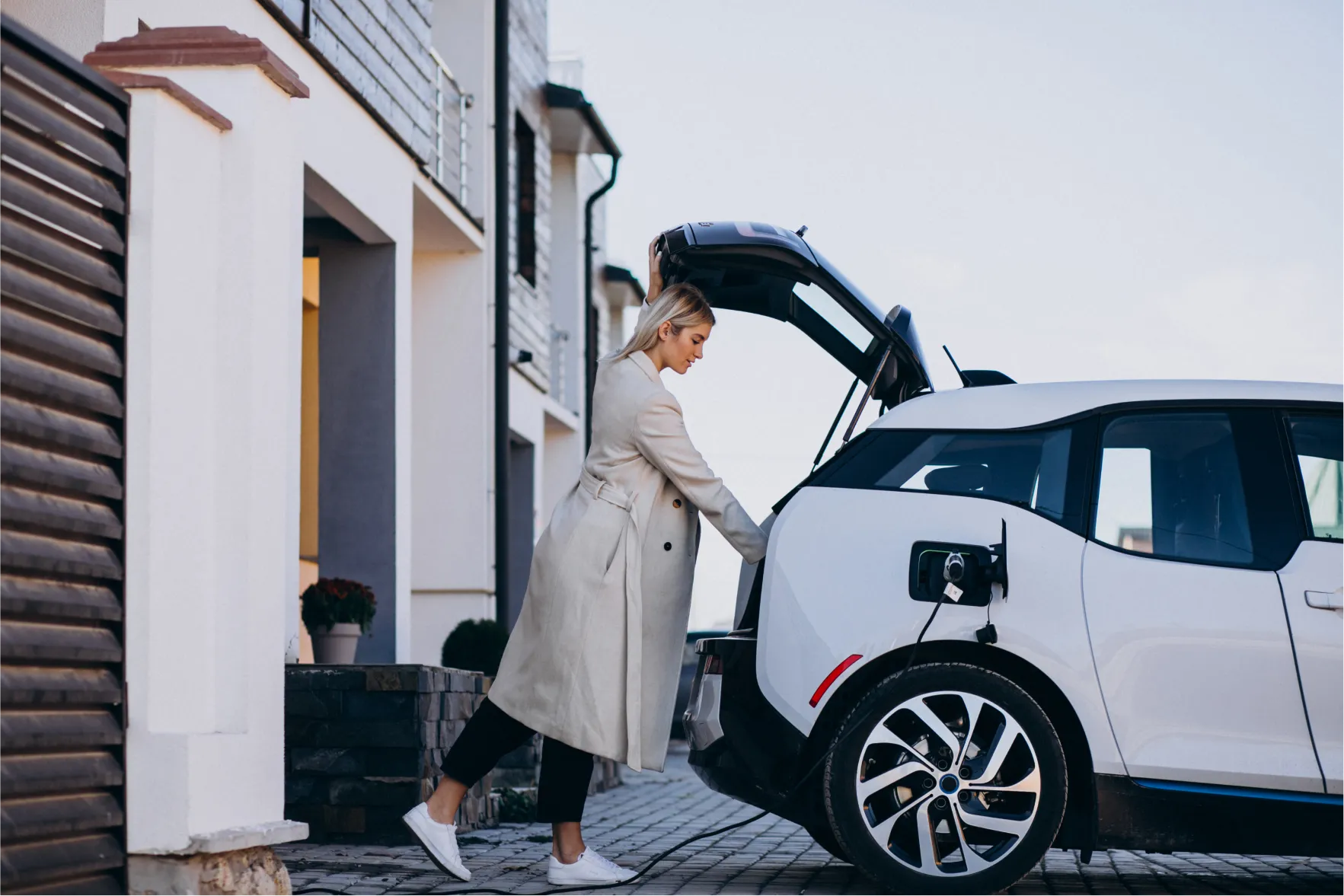 Woman loading the trunk of an EV car.
