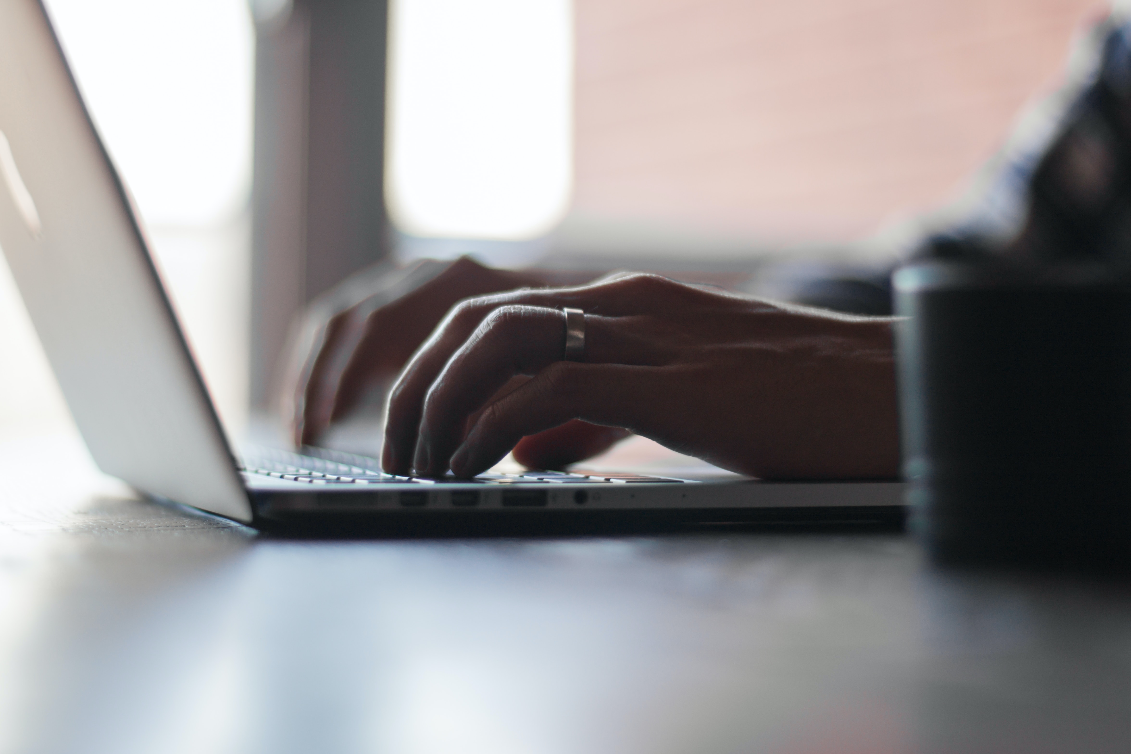 Mains tappant sur le clavier d'un ordinateur portable