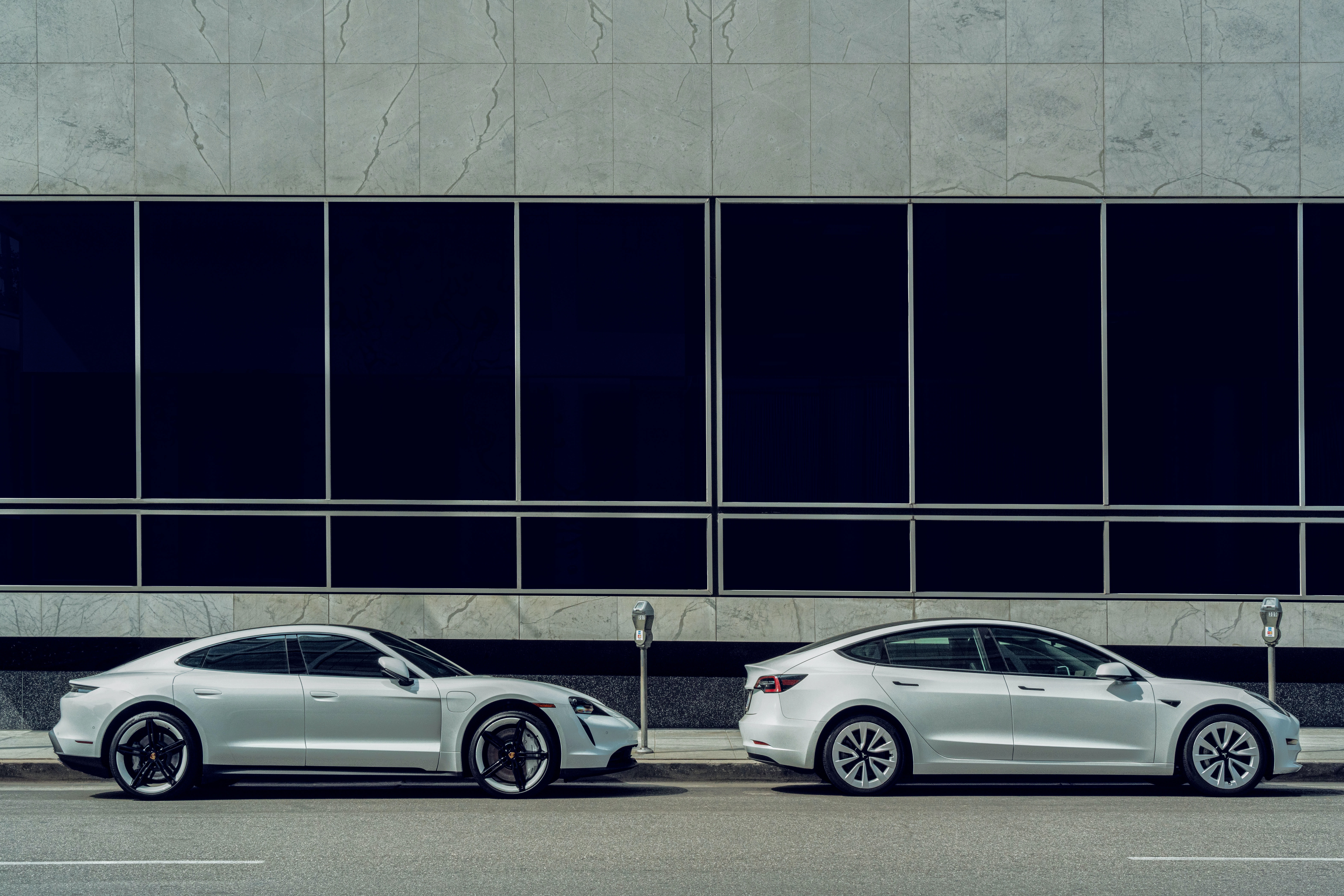 A Tesla and a Porsche Taycan electric cars parked in the street