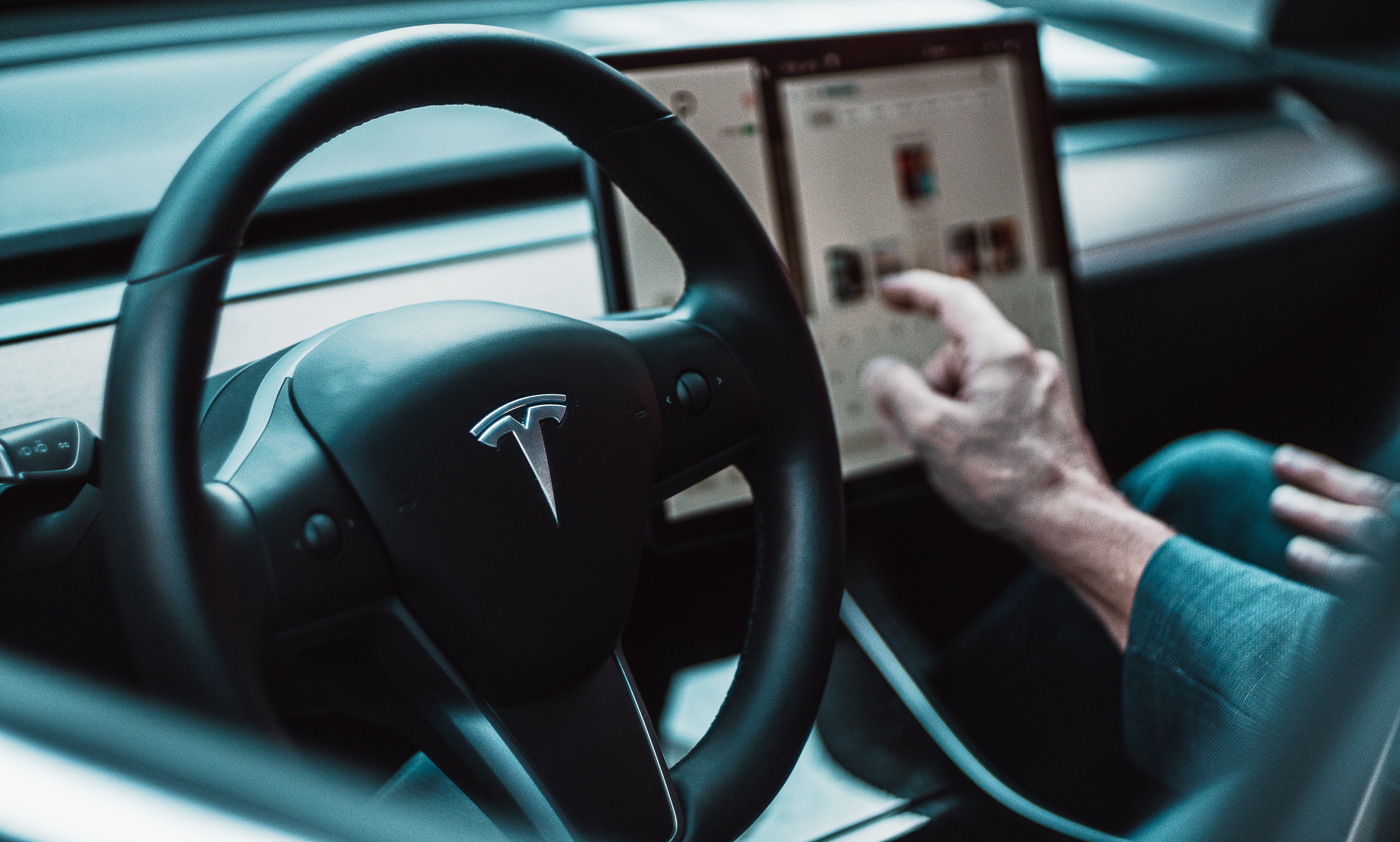 Hand adjusting screen of a Tesla car